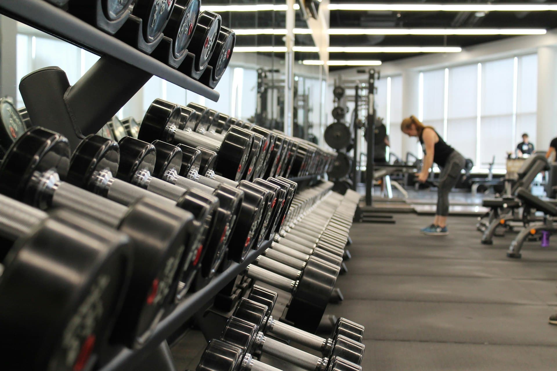Gym member working out with weights in a modern fitness studio